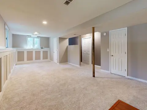 A finished basement with carpet and paneled walls