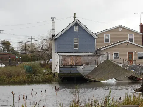 Houses beside the water in Howard Beach, Queens, with a deck broken loose after Hurricane Sandy