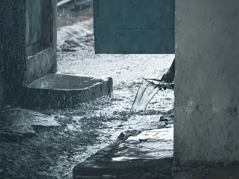 Rainwater pouring in through an open doorway