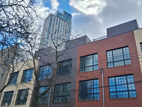 Newer apartment buildings and a tower behind older buildings in Long Island City