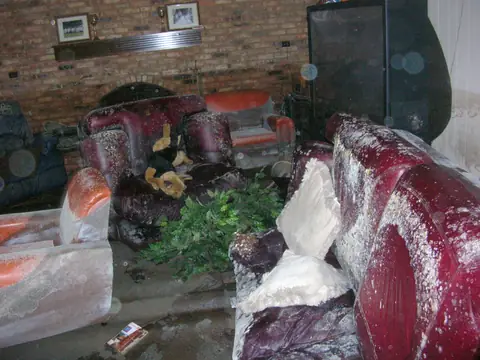 Water-soaked, moldy furniture in a living room after a flood