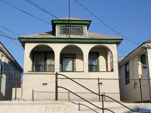 A stucco bungalow with an arched porch in the Rockaways, Queens
